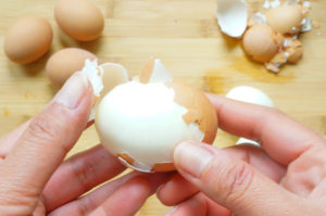 Peeling egg with hands