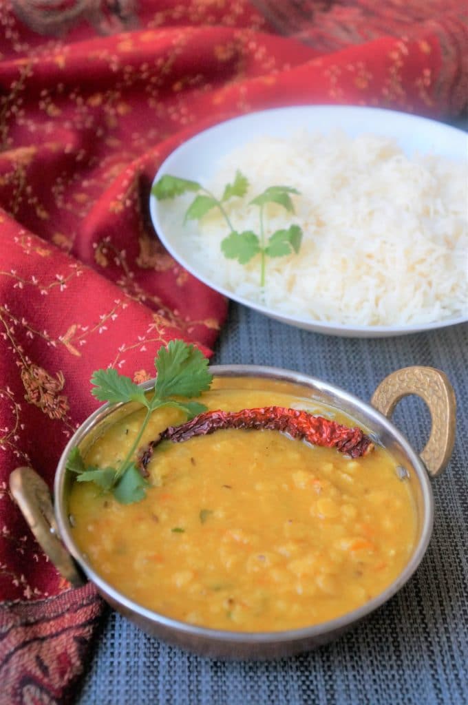 instant pot Dal Tadka (Yellow Lentils) in a pretty bowl with rice on the side