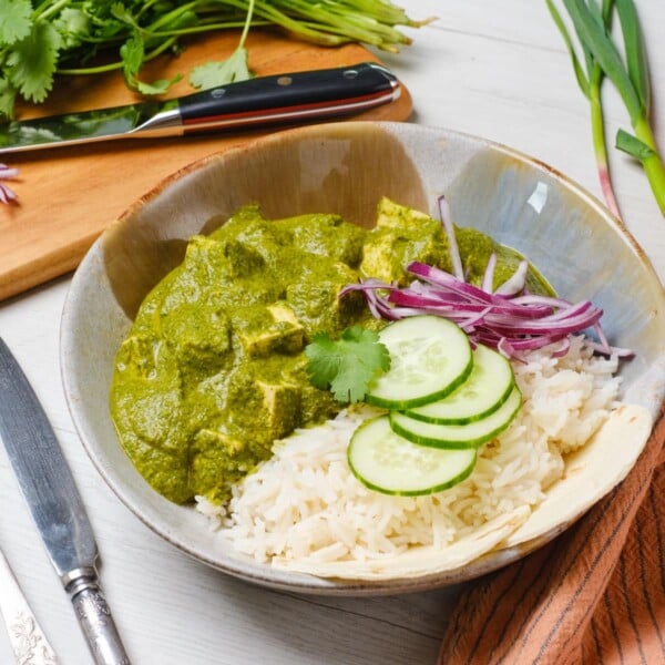 Vegan palak paneer with tofu served in a bowl with rice.