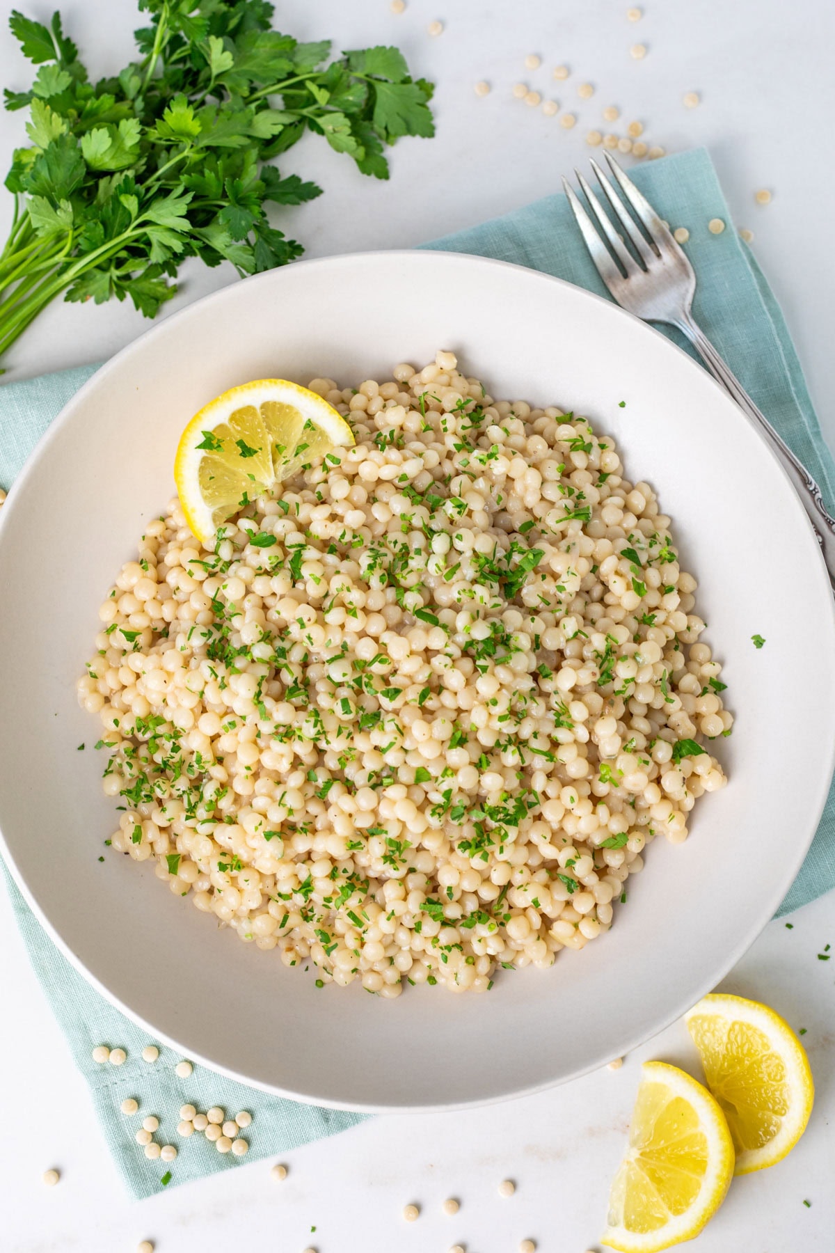 Instant Pot Couscous on a white plate topped with parsley