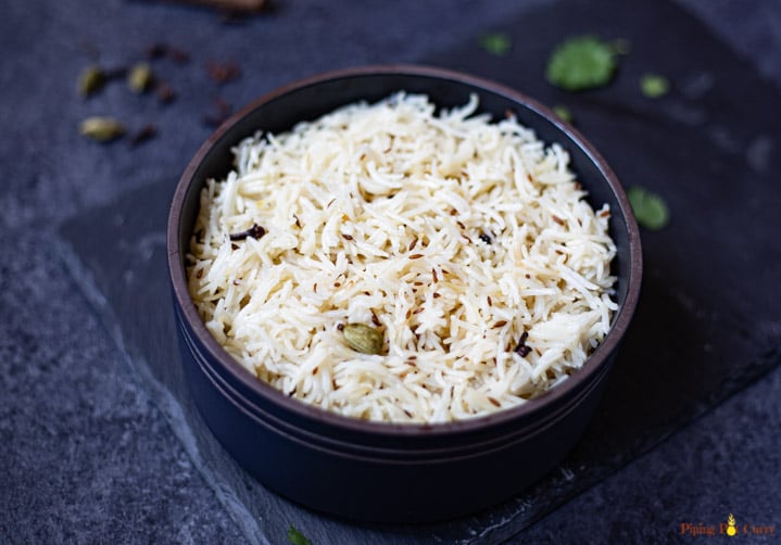 cumin rice in a black bowl