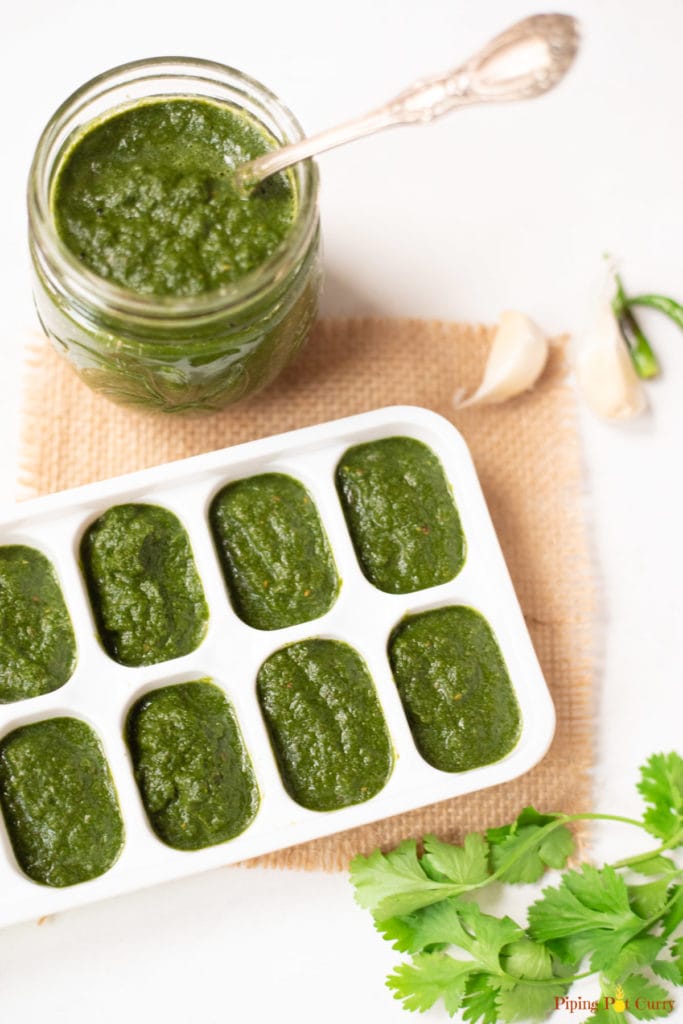 Mint cilantro chutney stored in ice-cube trays and in a glass container