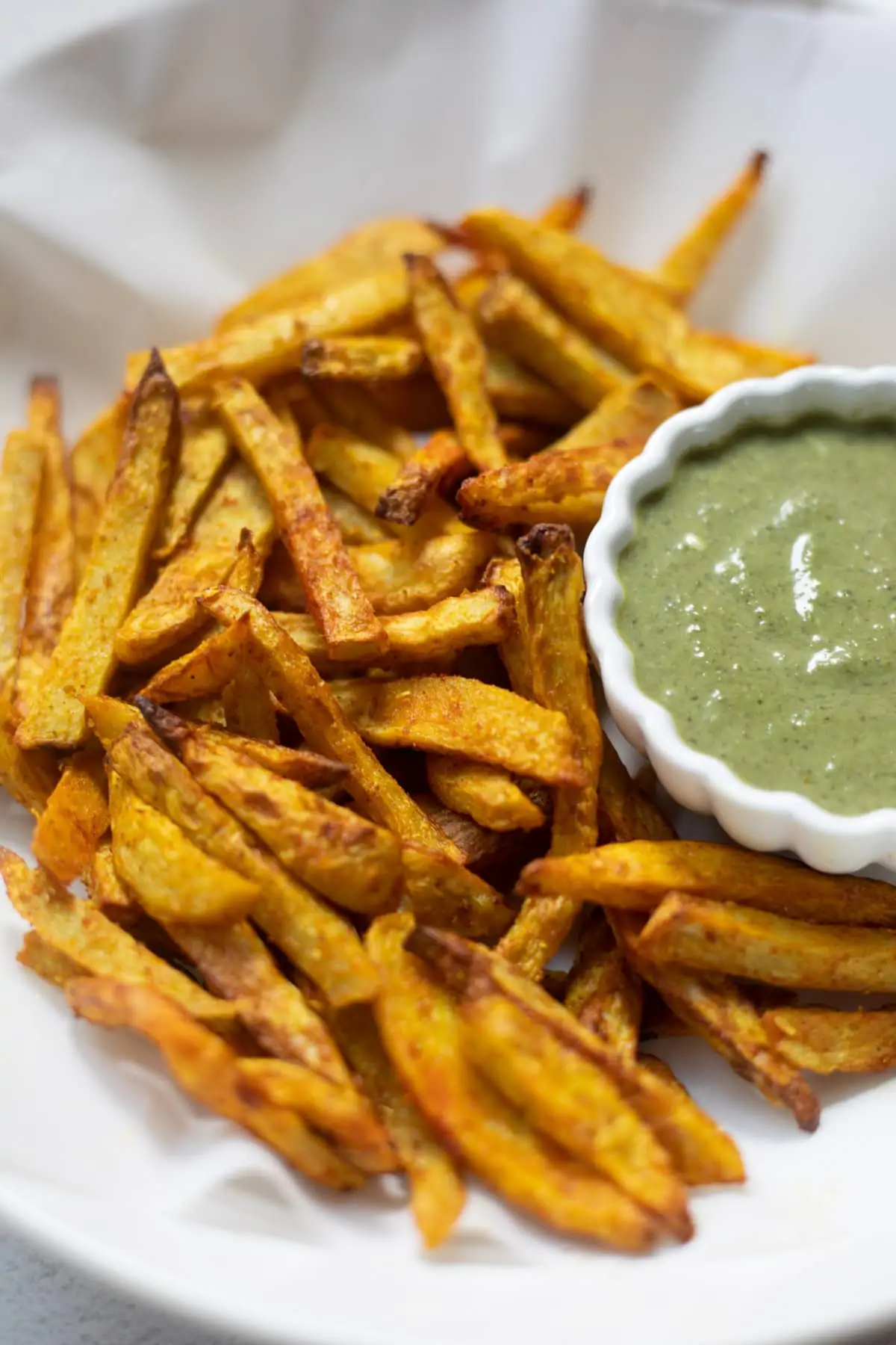 Taro fries in a white bowl with a creamy dip 