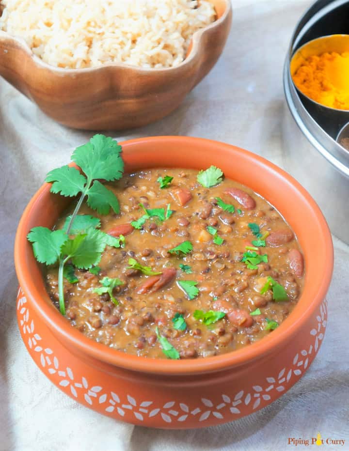 Dal Makhani made in the instant pot, served in a earthen pot with some brown rice and spices in the back