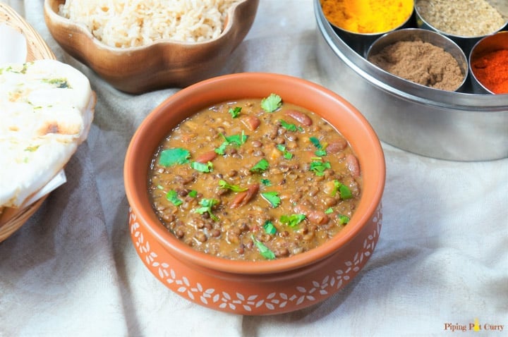 Dal Makhani made in the instant pot, served in a earthen pot with some brown rice and spices in the back