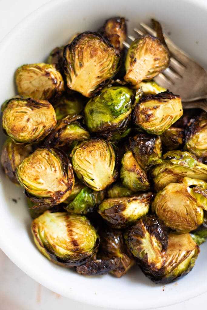 Not usual for a favorite, but these Air Fryer Brussels sprouts have become a favorite. Crispy on the outside and tender on the inside...yummy! Brussels sprouts with balsamic vinegar in a white bowl