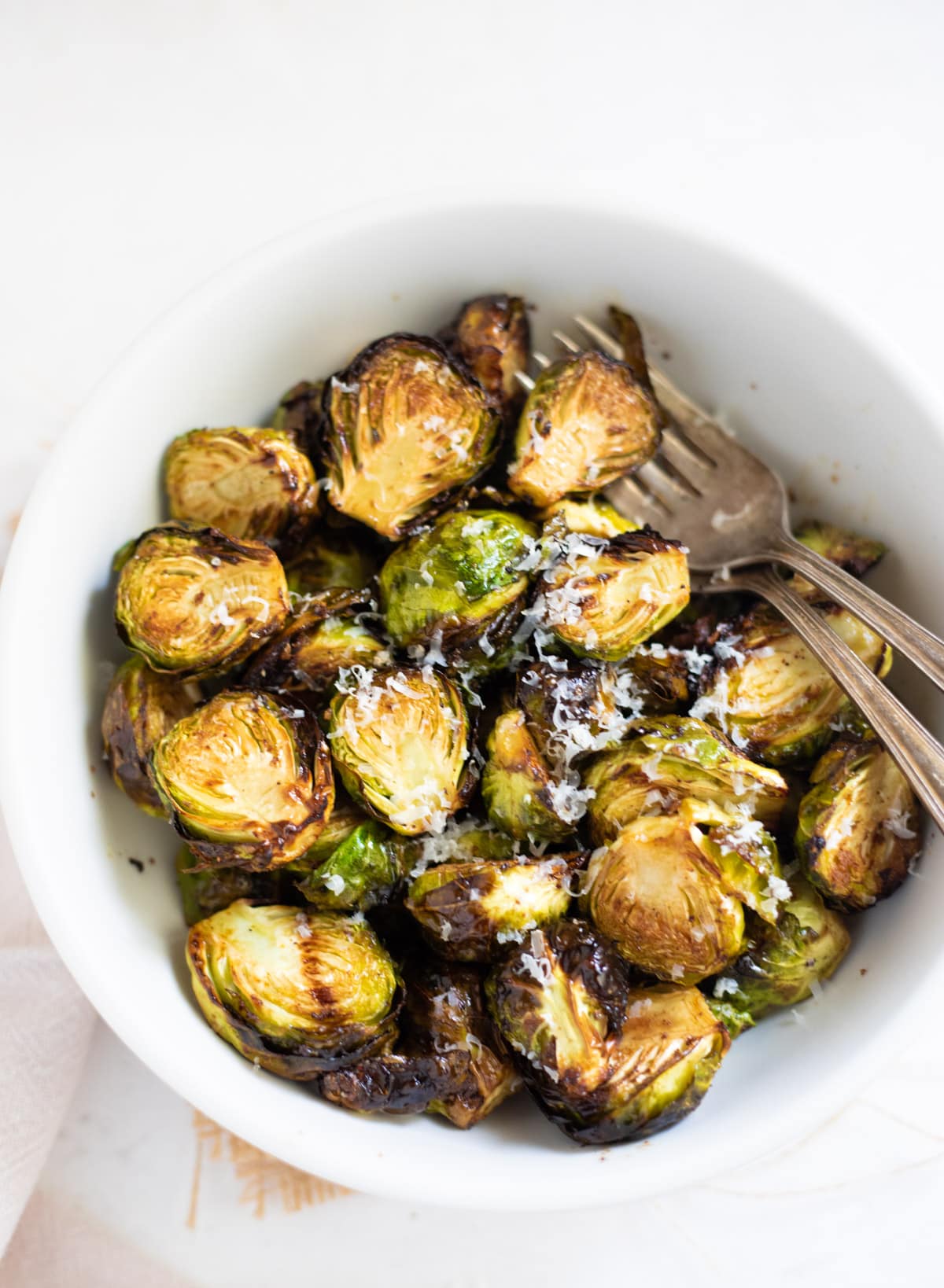Roasted Air Fryer Brussels sprouts in a white bowl topped with parmesan