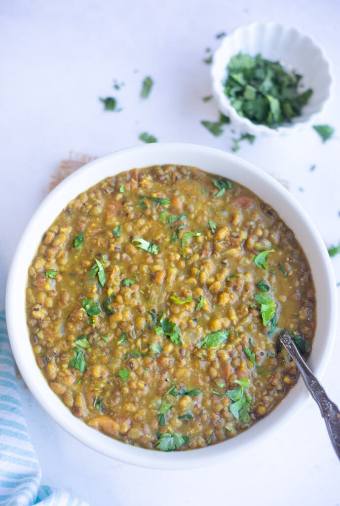 Green Moong Dal curry in a bowl garnished with cilantro