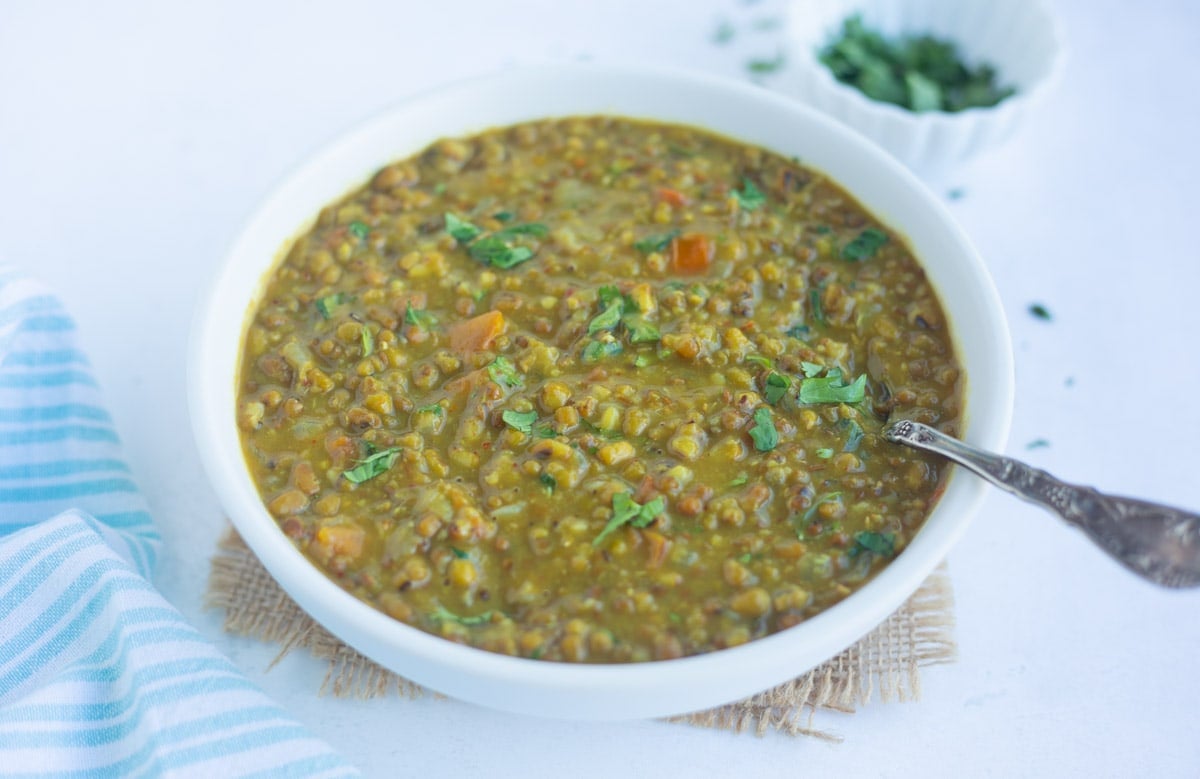 Creamy delicious Green Moong lentils soup in a bowl garnished with cilantro leaves