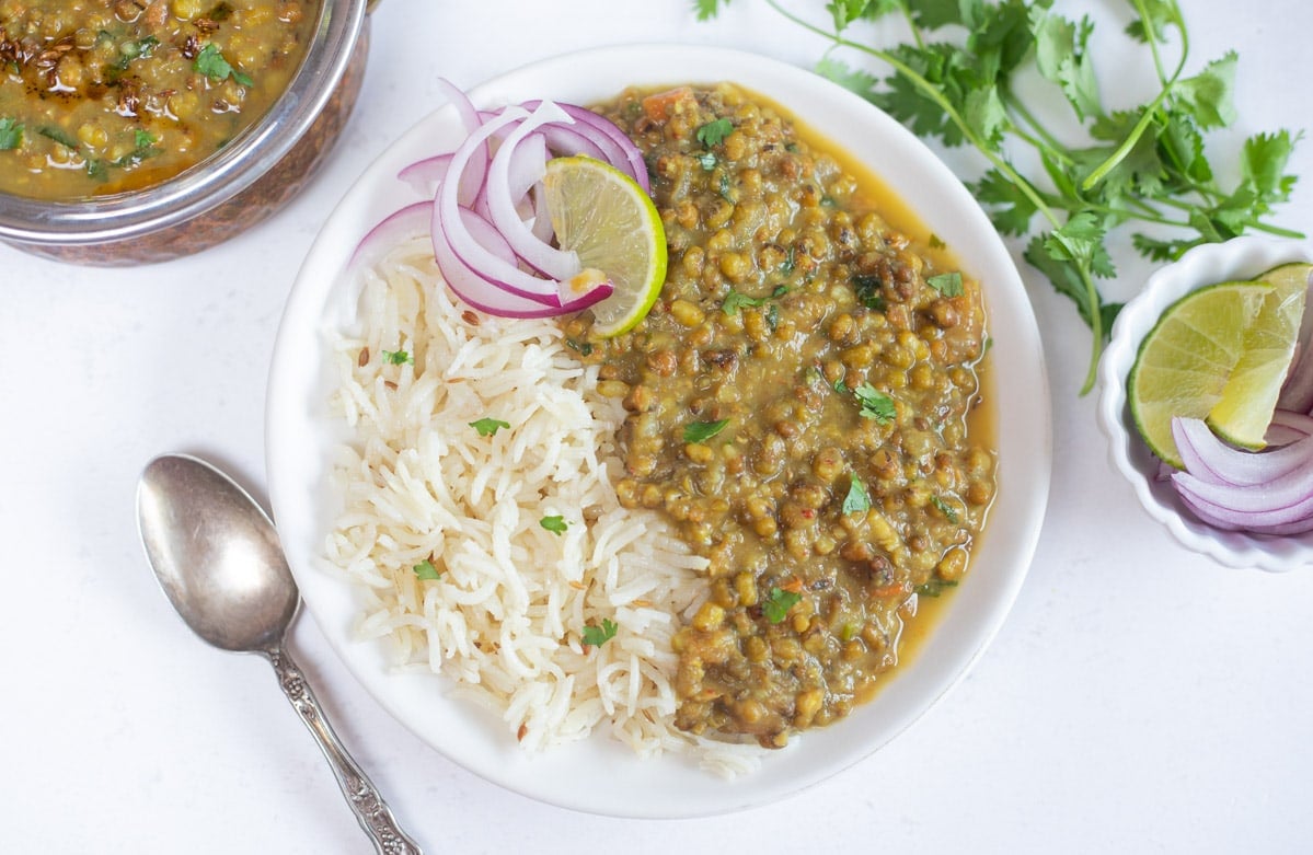 Green mung dal served with rice with red onions and lime. 