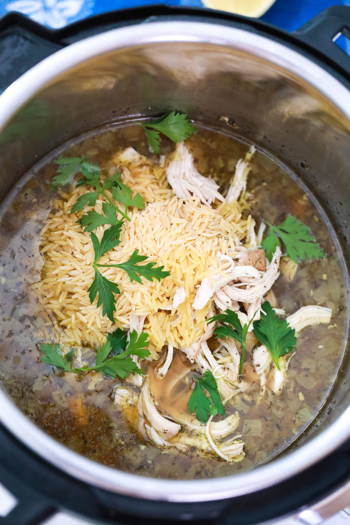 shredded chicken and orzo added to make lemon chicken orzo soup in the pressure cooker