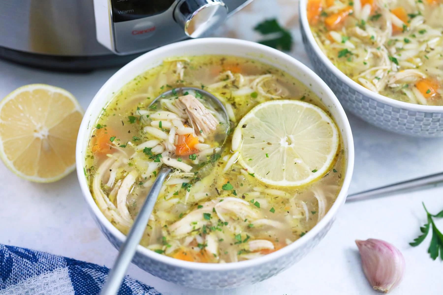 greek lemon chicken soup with orzo in a bowl in front of the instant pot