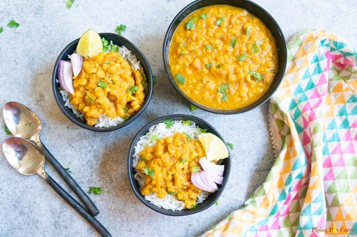 Chana Dal made in pressure cooker served in a bowl and topped on rice