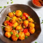 Flavorful and easy Garlic Chili Potatoes, made with steamed potatoes, garlic, chili sauce and honey, sprinkled with green onions and sesame seeds. Enjoy them as an appetizer or side! #chilipotatoes #garlicpotatoes #indochinese #chinese #vegan | pipingpotcurry.com