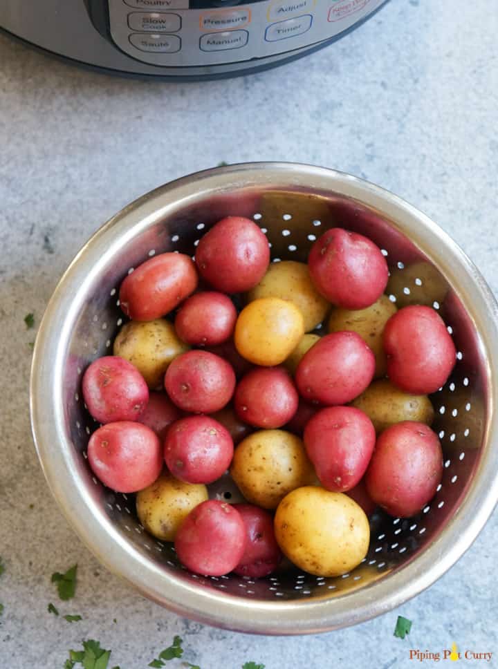 Baby Potatoes in a steamer basket in front of an Instant Pot 
