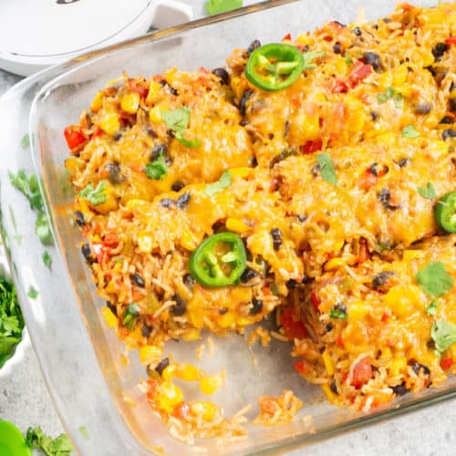 Healthy Vegetarian Mexican Rice & Bean Casserole is easy to make and filled with cheesy goodness, along with brown rice and lots of veggies. This is an easy gluten free & vegetarian casserole for a weeknight dinner or your next party!