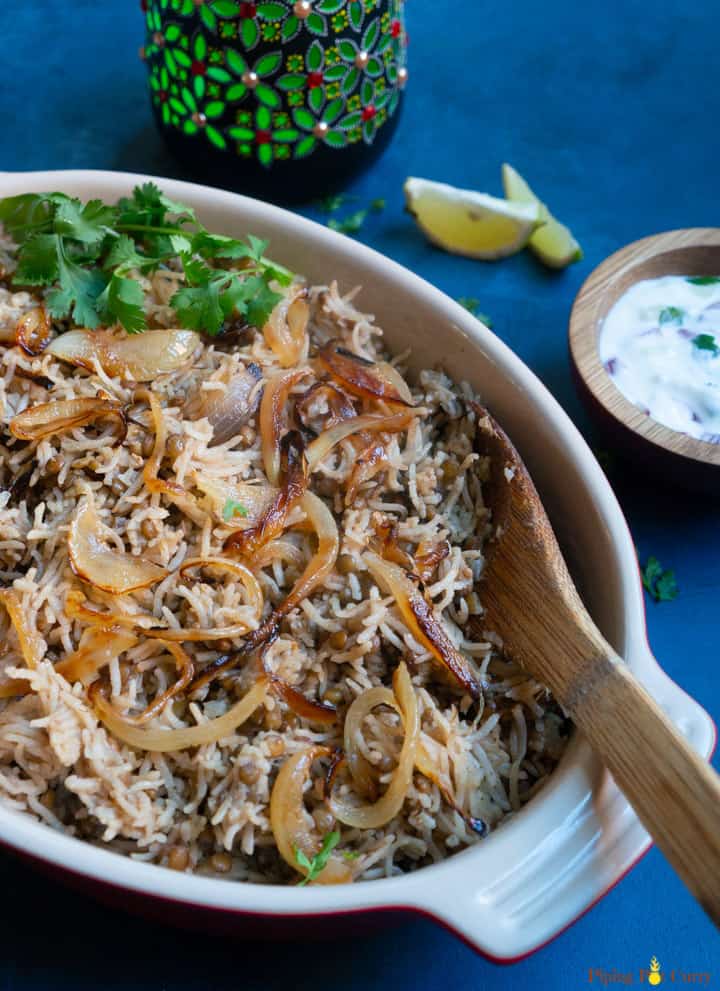 Instant Pot Lentils and Rice (Mujadara) in a serving bowl with yogurt and lemon on the side.