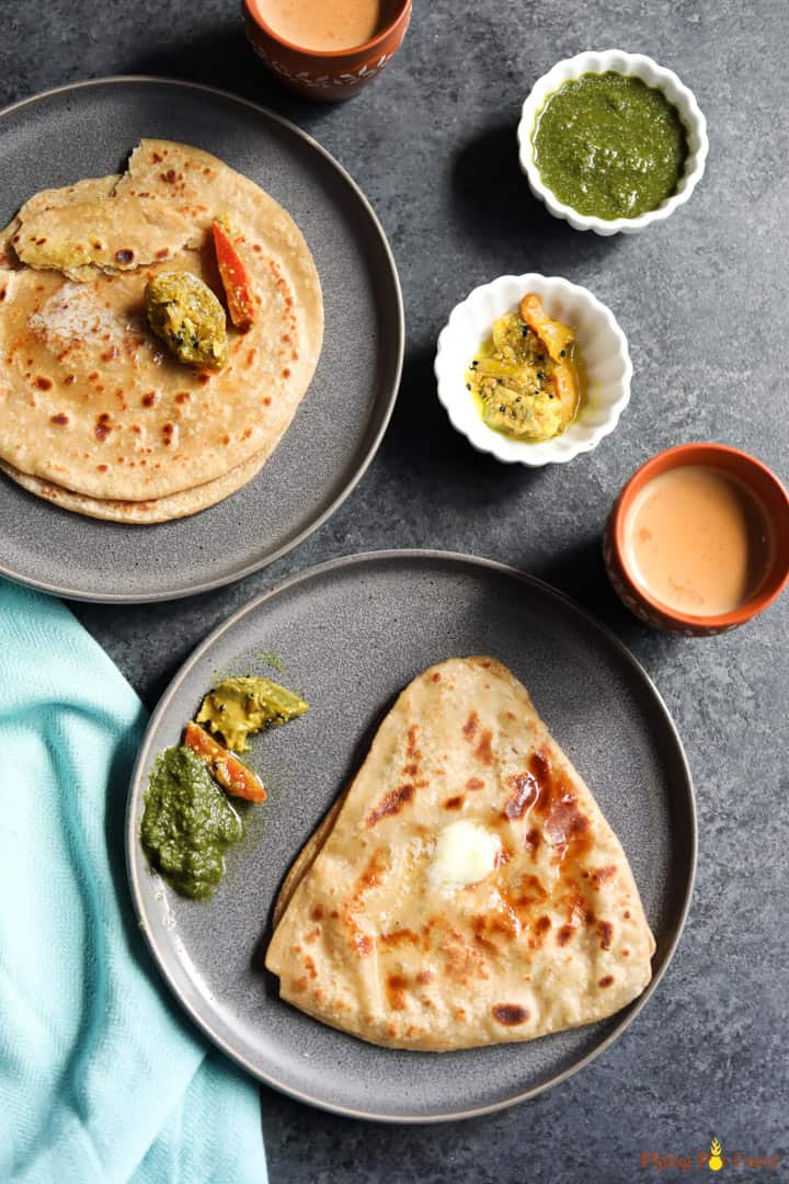 Paratha, pan fried indian flatbread along with pickle, chutney and chai