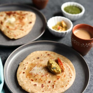 Paratha, pan fried indian flatbread along with pickle and chai