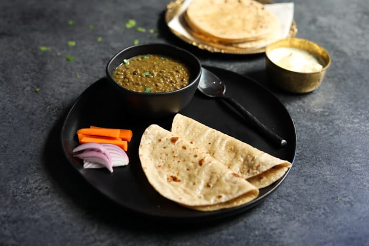 Phulka Roti - Chapati - Whole Wheat Indian Flatbread in a plate with dal