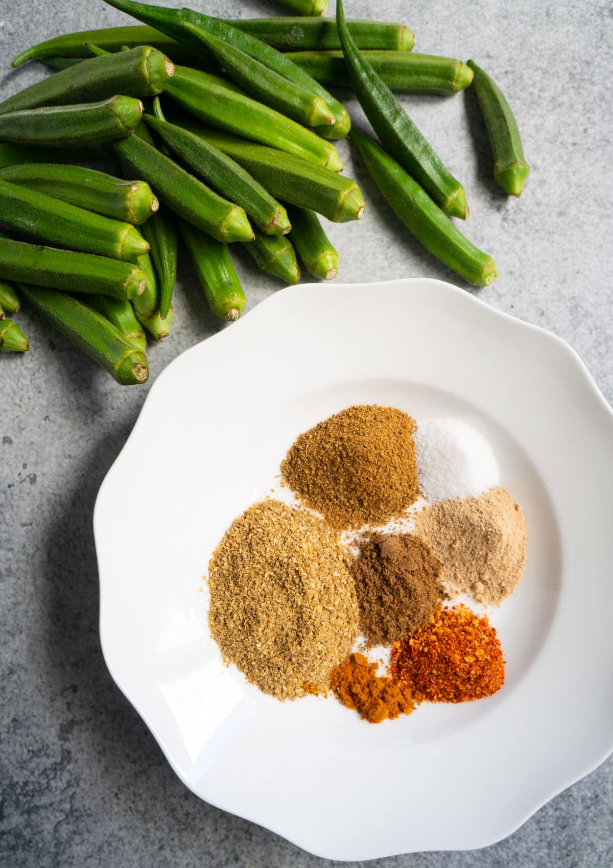 Variety of spices in a white plate to be mixed and stuffed in the okra to make stuffed okra
