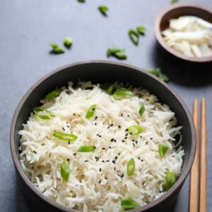Coconut Rice cooked in pressure cooker topped with coconut flakes