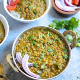 Masoor Dal made in instant pot served in a bowl along with onions, tomatoes