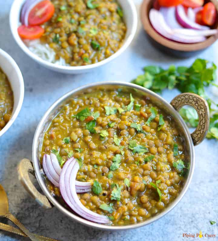 Masoor Dal made in instant pot served in a bowl along with onions, tomatoes