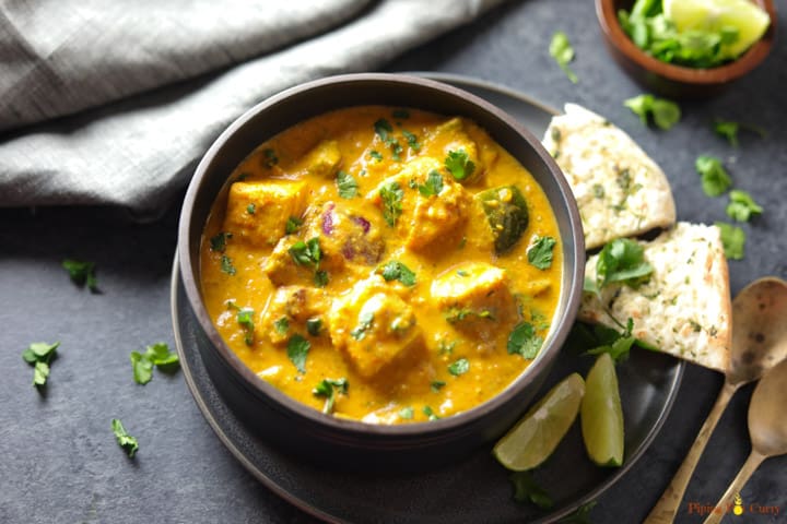 Instant Pot Paneer Tikka Masala served in a bowl with some naan and limes on the side.