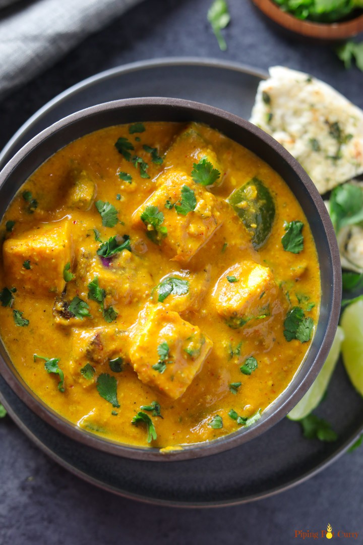 Paneer Tikka Masala made in Instant Pot served in a bowl with some naan and limes on the side.