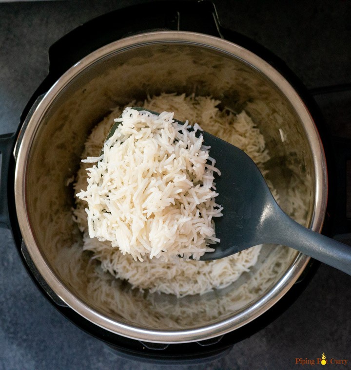 Coconut Rice cooked in pressure cooker topped with coconut flakes 