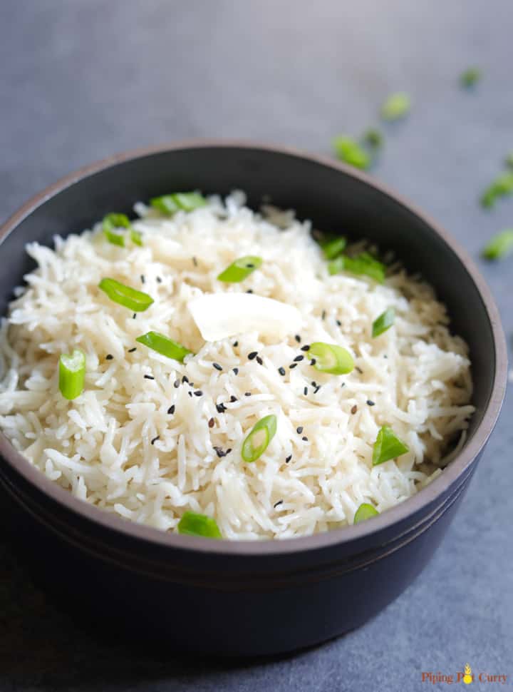 Coconut Rice cooked in pressure cooker topped with coconut flakes 