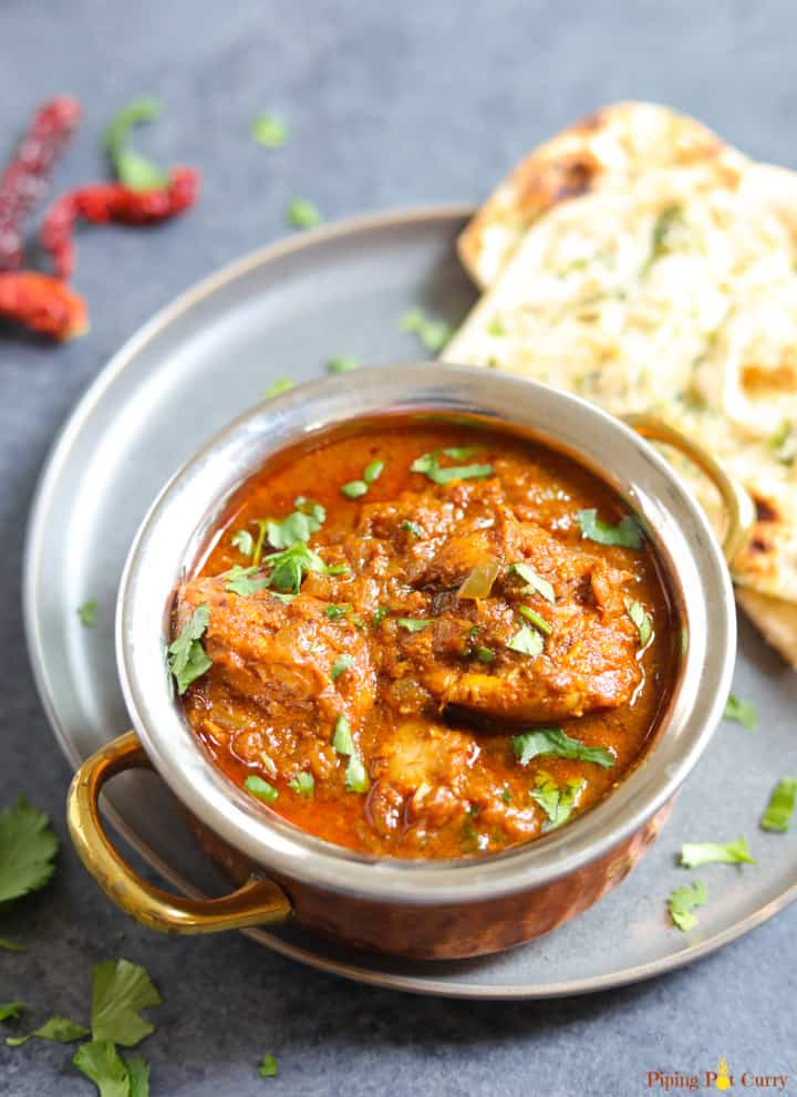 Authentic Chicken Vindaloo served in a bowl along with naan bread
