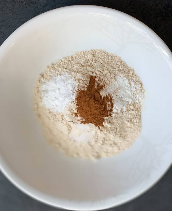 Mix dry ingredients to make Whole Wheat Healthy Carrot Muffins in a white bowl