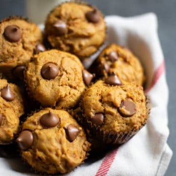 Healthy Carrot Muffins in a basket with a bottle of milk in the back