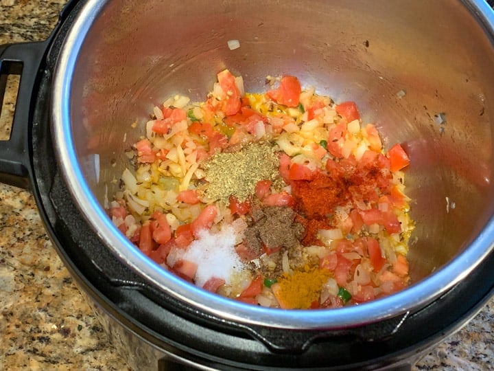 Add tomatoes and spices to make Lauki Chana Dal in pressure cooker