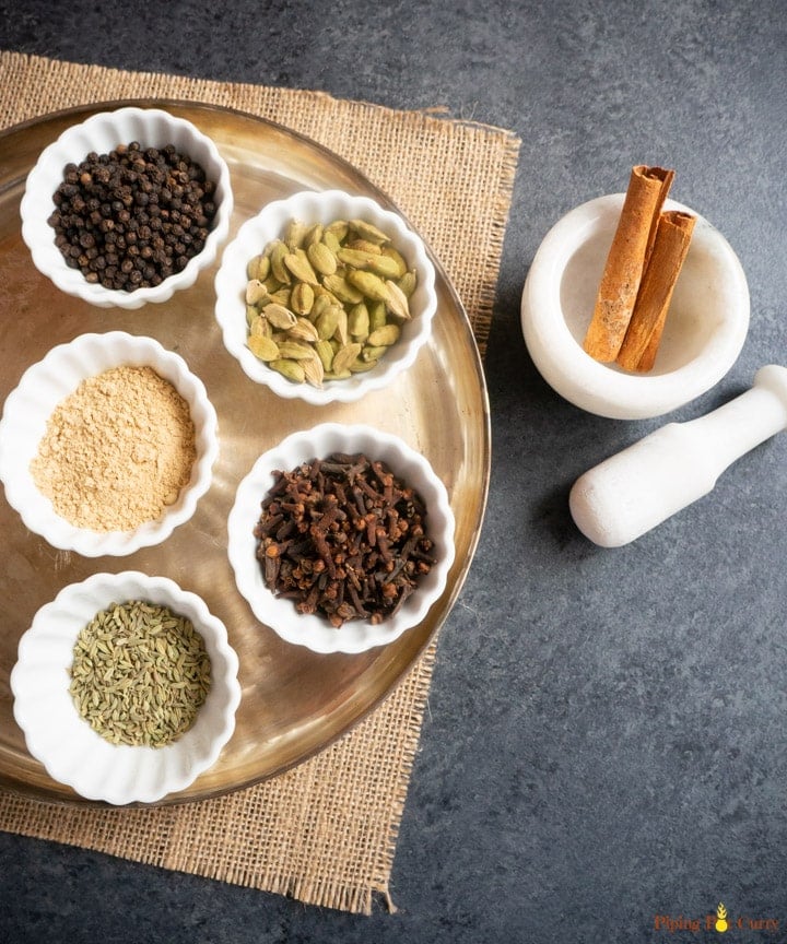 Whole spices in small white bowls 