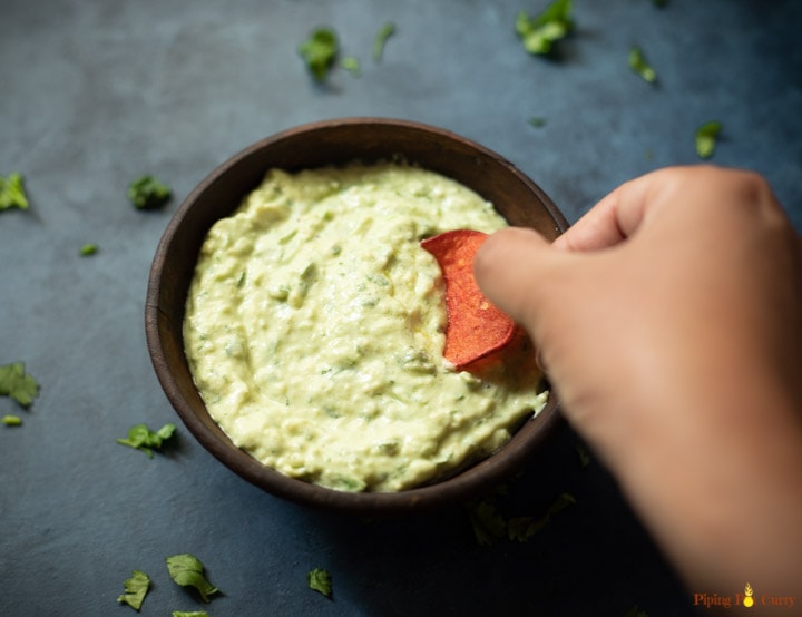 Dipping a chip in a creamy avocado sauce