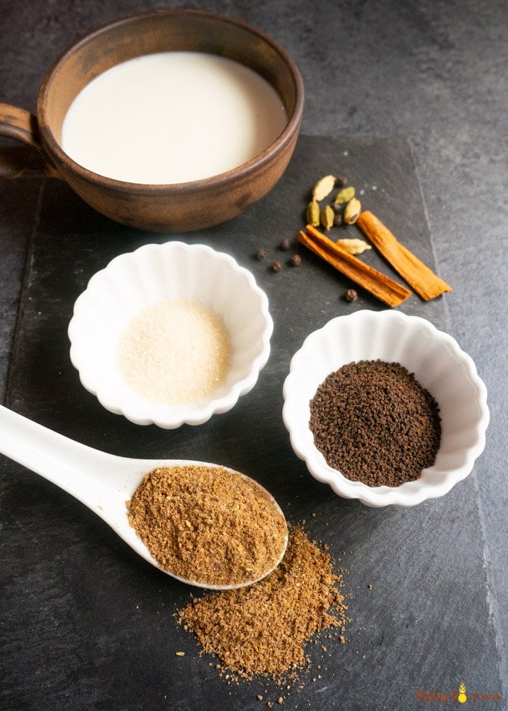 Ingredients to make masala tea. Masala tea powder, tea leaves, sugar, spices, milk
