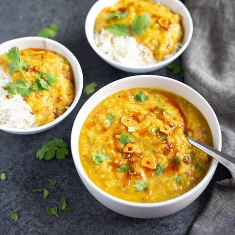 Red Lentils served in 3 bowls over rice and topped with cilantro