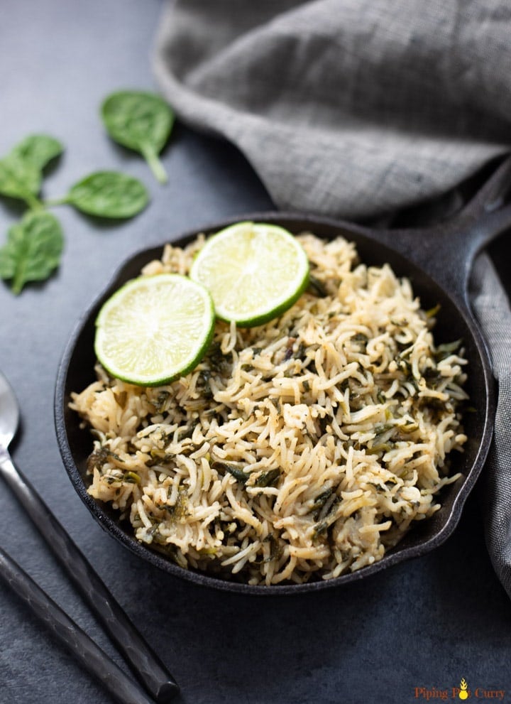 Spinach Rice in a cast-iron pan topped with lemon slices