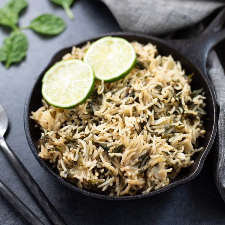 Spinach Rice in a cast-iron pan topped with lemon slices