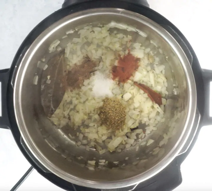 Onions along with spices in an electric pressure cooker