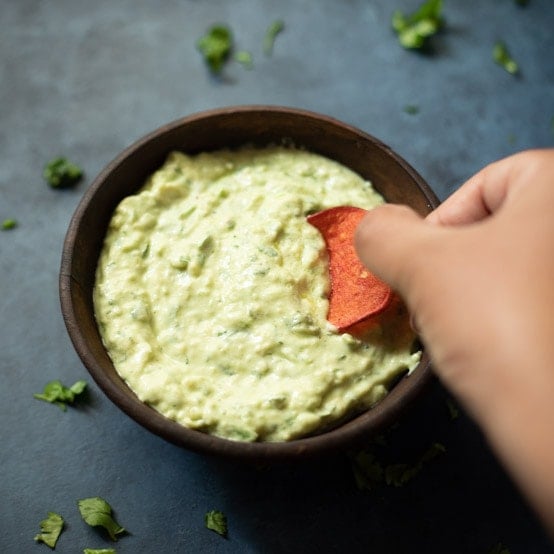Dipping a chip in a creamy avocado sauce