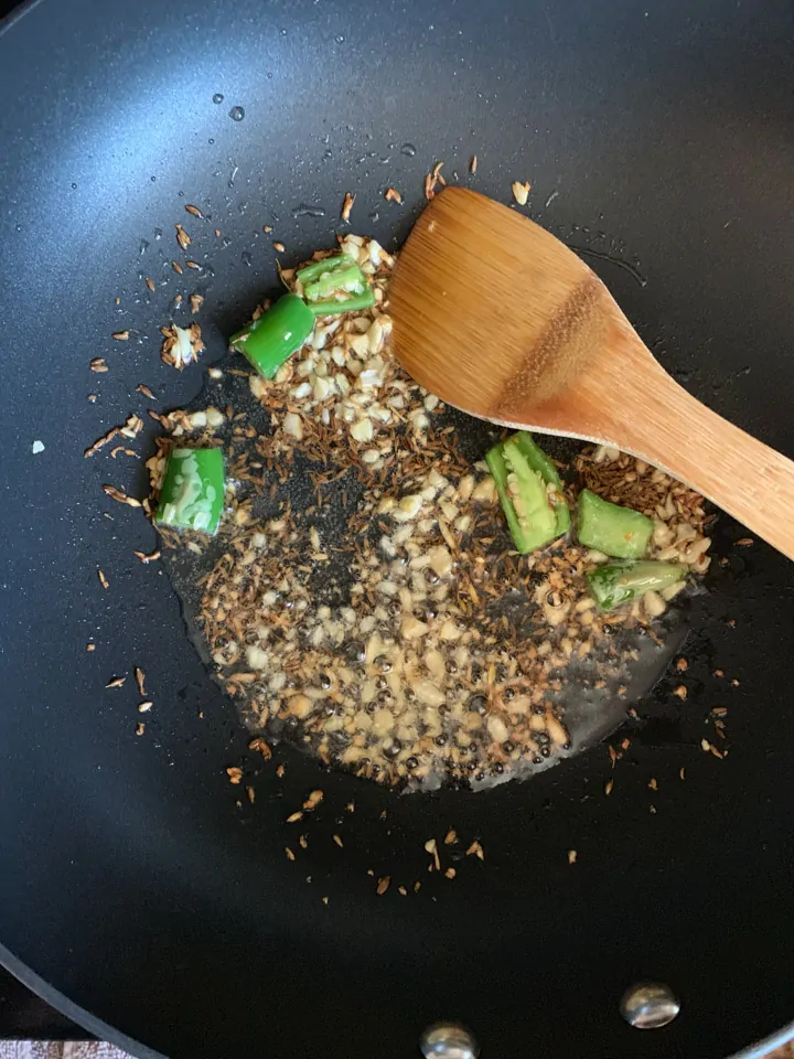 Aloo Gajar Matar- step 1 Oil with cumin, green chili and garlic in a wok