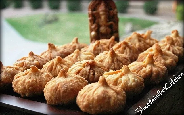 Fried Modak or dumplings in front of Lord Ganesha idol