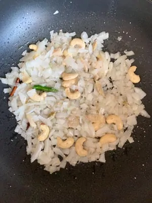 Sautéed onions with cashews in a wok