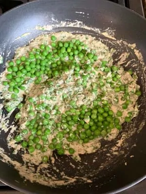 Green peas added to a creamy white sauce