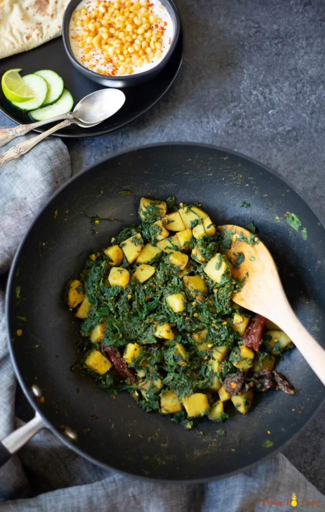 Alu Palak in a large wok or kadai