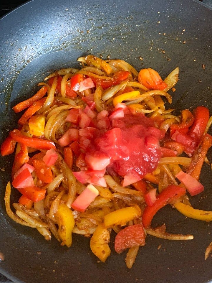 Paneer Jalfrezi step 4 - Piping Pot Curry Onions, peppers and tomato in a wok